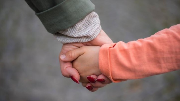 Une adulte et un enfant qui se tiennent la main