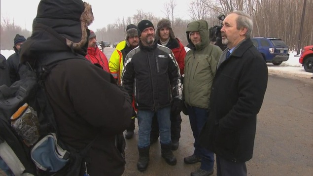 Jean-Guy Dubois dans un cercle avec les syndiqués en face de l'usine