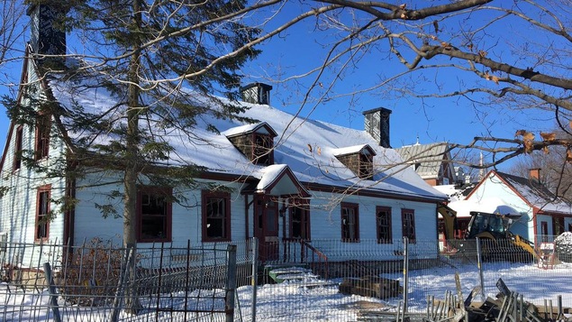 La maison est ceinturée d'une clôture de métal.