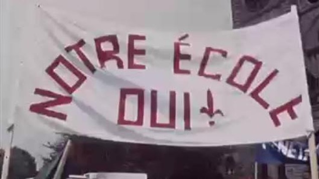 Grande bannière avec l'inscription «Notre école OUI» dans une manifestation