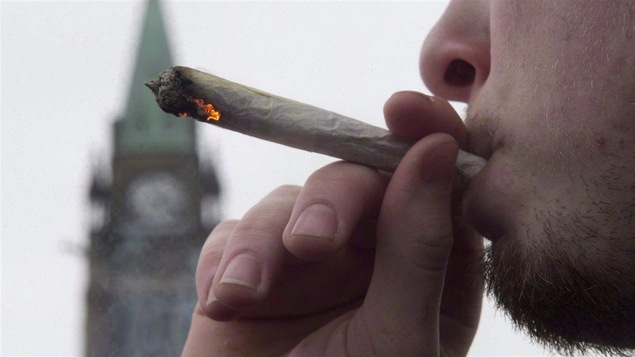 Un homme fume un joint de marijuana