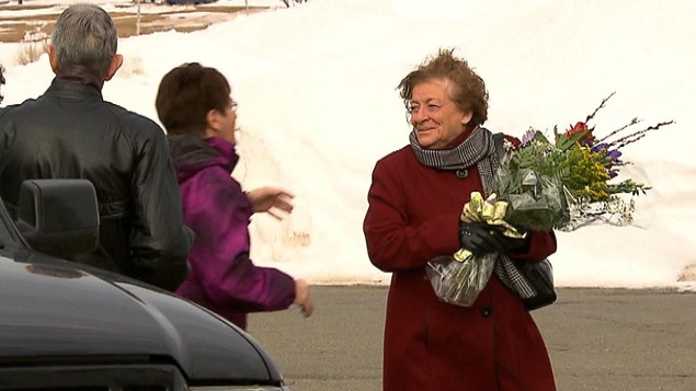 Lucie Cormier à l'extérieur de l'église avec un bouquet de fleurs dans les bras.