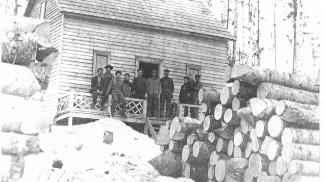 Des bûcherons sur la galerie d'une petite maison en bois