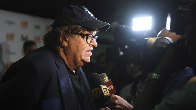 Le réalisateur américain Michael Moore répond aux questions des journalistes sur le tapis rouge du TIFF.