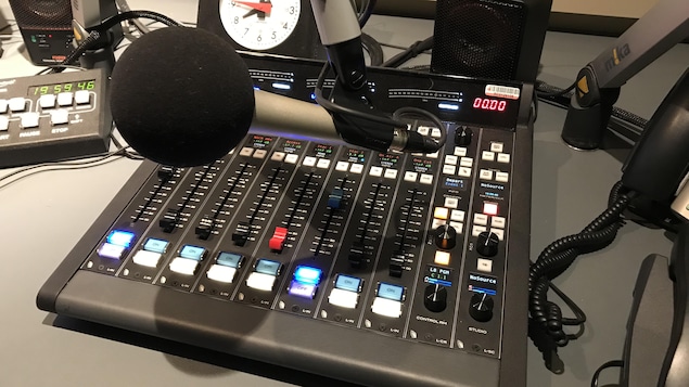 Un micro et une console de son dans un studio