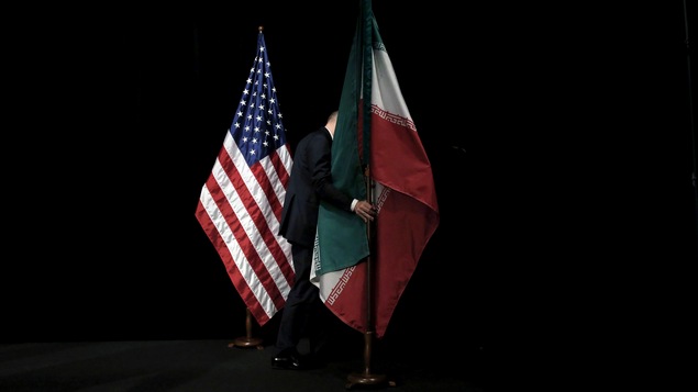 Photo d'archives montrant un homme retirant le drapeau iranien à la suite d'une réunion internationale sur le nucléaire iranien à Vienne, en juillet 2015.