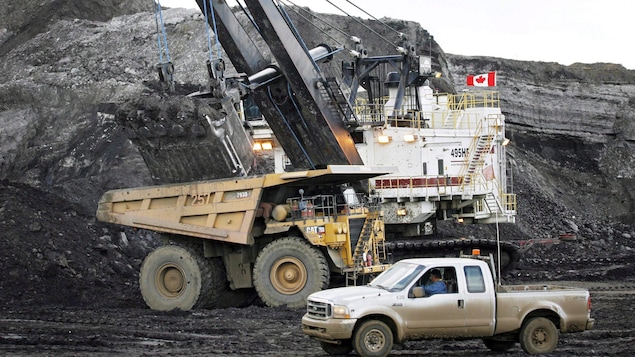 Une pelle minière remplit un camion de transport sur une mine de sables bitumineux près de Fort McMurray, en Alberta. Une pelle minière remplit un camion de transport sur une mine de sables bitumineux près de Fort McMurray, en Alberta.
