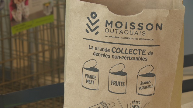 Un sac en papier brun avec le logo de Moisson Outaouais.