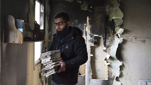 Une homme ramasse les débris dans une mosquée ravagée par un feu criminel en novembre 2015, à Peterborough.