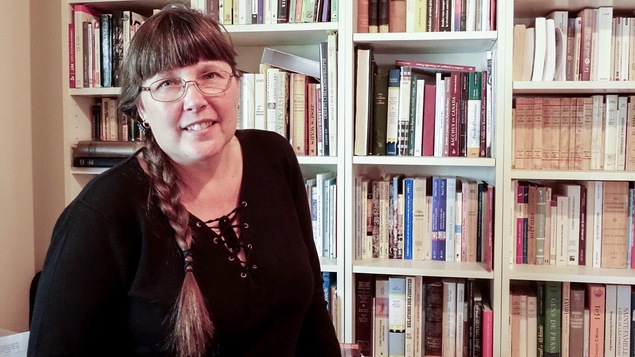 L'écrivaine Mylène Gilbert-Dumas pose devant une bibliothèque, dans son bureau.