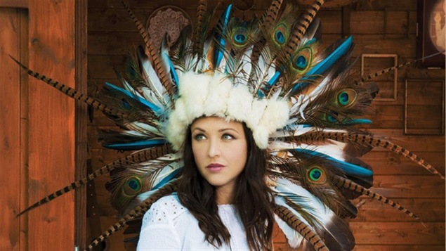 La chanteuse Natasha St-Pierre avec une coiffe ressemblant à une coiffe autochtone traditionnelle