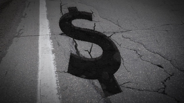 Un signe de dollar sur une chaussée fissurée Un signe de dollar sur une chaussée fissurée