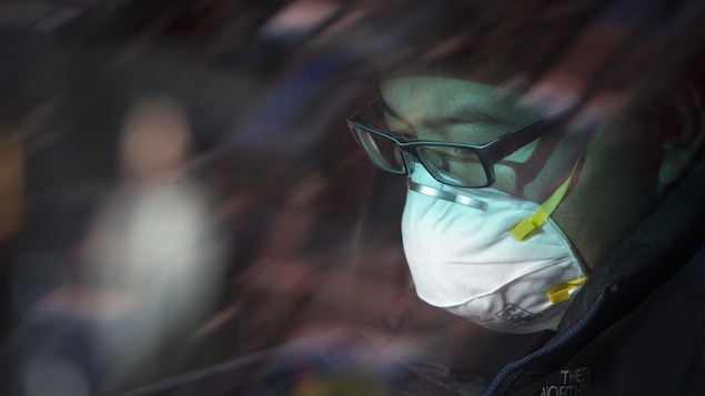 Un homme portant un masque afin d'éviter une infection virale.