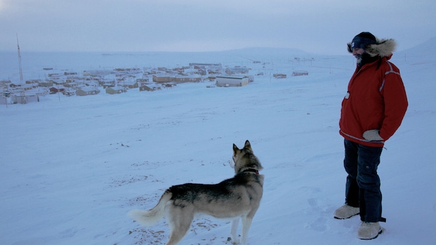 Martin et le chien Sky dans les glaces devant le village de Resolute