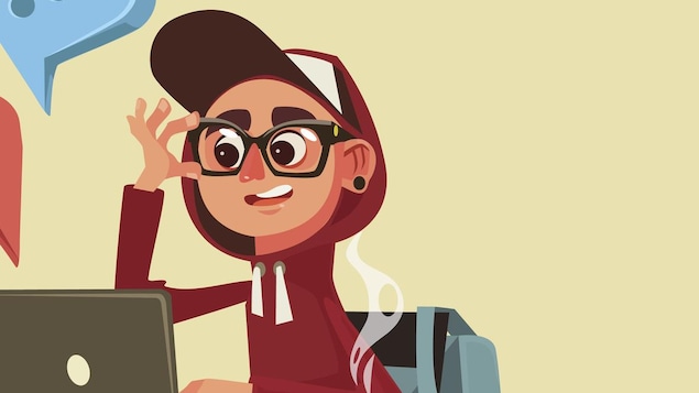 Un jeune avec des lunettes est assis devant un ordinateur
