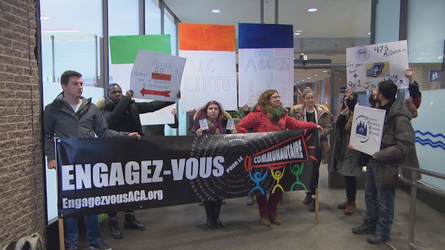 Des membres des organismes communautaires tiennent des pancartes au palais de justice de Gatineau. Des membres des organismes communautaires tiennent des pancartes au palais de justice de Gatineau.