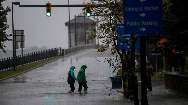 Deux personnes traversent une route inondée en Caroline du Nord.