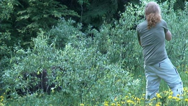 Un homme se rapproche dangereusement d'un grizzly pour le prendre en photo.