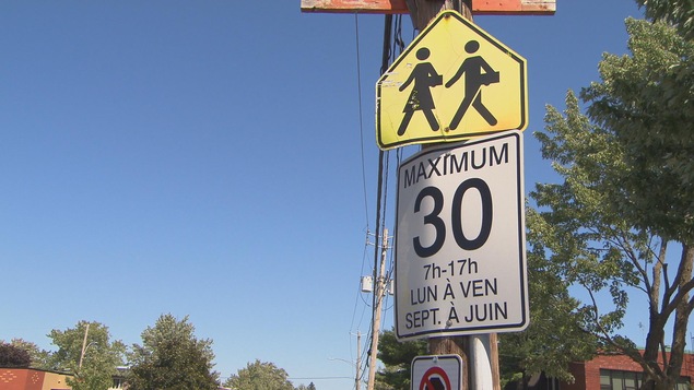 Panneau de traverse d'écoliers et panneau de limite de vitesse à 30 km/h.
