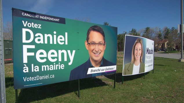 Les pancartes géantes des candidats Daniel Feeny et Maude Marquis-Bissonnette près d'une rue, le 26 avril 2024. 