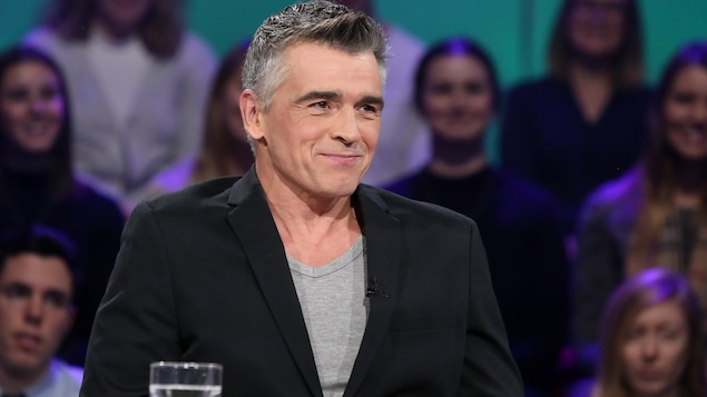 L'homme sourit en regardant l'animateur. L'homme sourit en regardant l'animateur.