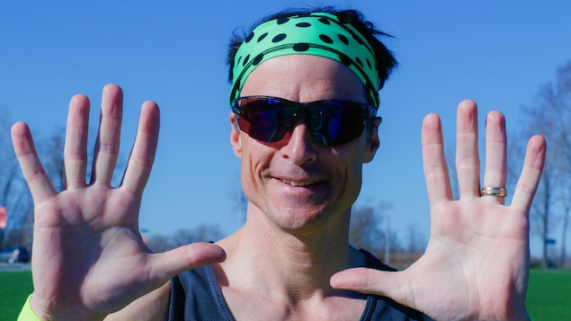 Patrick Charlebois avec des lunettes fumées et un bandeau qui montre ses dix doigts