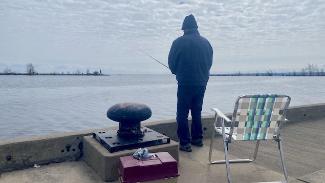 Un homme pêche en bordure du lac Saint-Jean.