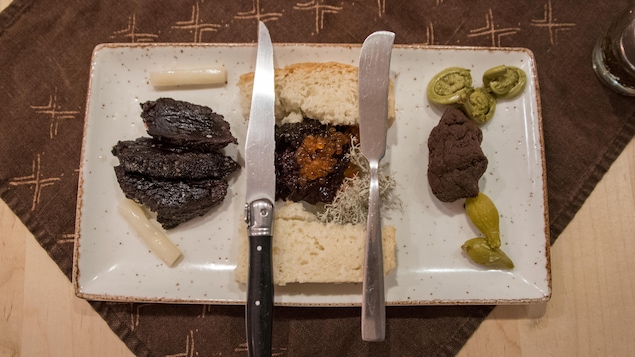 Un plat, deux couteaux et trois morceaux de viande