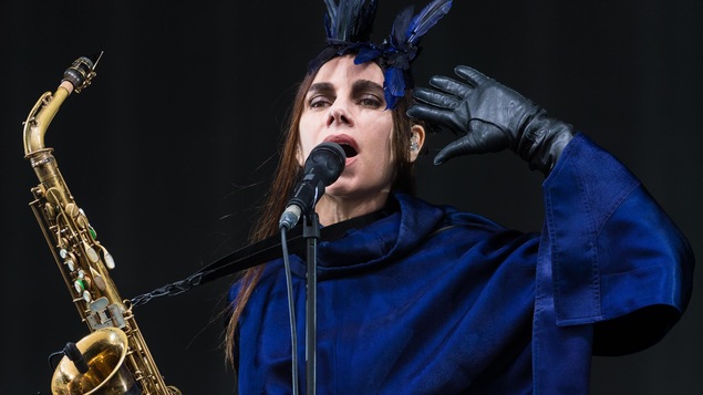 PJ Harvey, saxophone à la main, chante lors d'un concert au Glastonbury Festival, au Royaume-Uni, en juin 2016. PJ Harvey, saxophone à la main, chante lors d'un concert au Glastonbury Festival, au Royaume-Uni, en juin 2016.