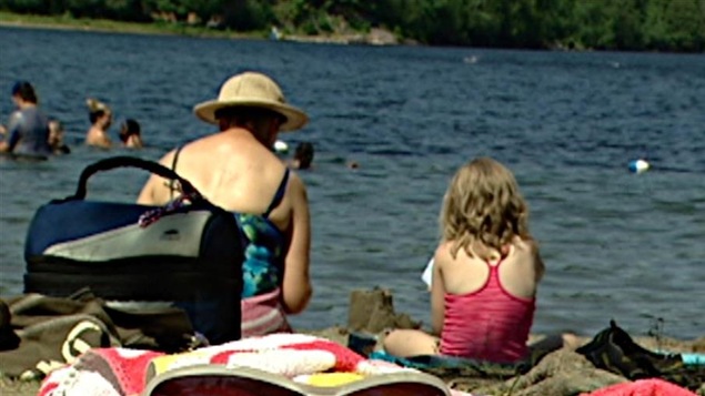Une femme et une fillette sont assises côte à côte et construisent un château de sable. Une femme et une fillette sont assises côte à côte et construisent un château de sable.