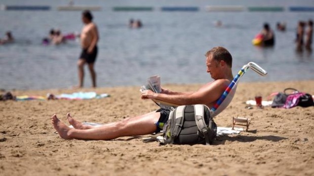 Un homme assis sur une chaise de plage, à la plage de Mooney's Bay à Ottawa. (Archives)