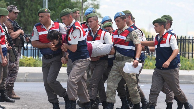 Des policiers transportent jusqu'au tribunal un ancien militaire soupçonné d'avoir conspiré contre le président Erdogan. Des policiers transportent jusqu'au tribunal un ancien militaire soupçonné d'avoir conspiré contre le président Erdogan.