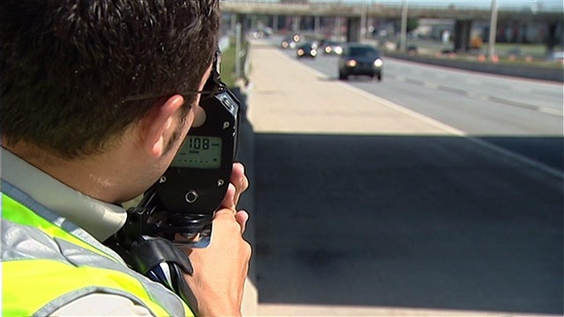Un policier mesure la vitesse des automobilistes à l'aide d'un radar.