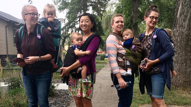 4 femmes dans la rue avec leurs bébés dans des porte-bébés 4 femmes dans la rue avec leurs bébés dans des porte-bébés