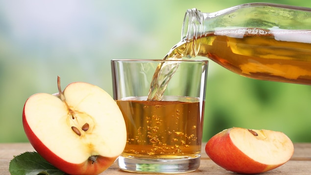 On verse du jus de pommes dans un verre.