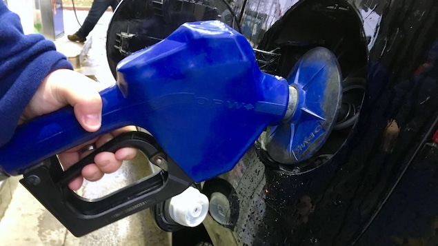 Une automobiliste fait le plein de son véhicule.