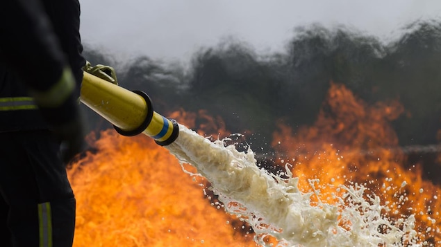Un pompier qui arrose un feu. Un pompier qui arrose un feu.