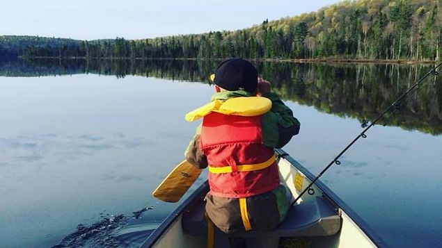 Un enfant sur une embarcation porte sa veste de flottaison.