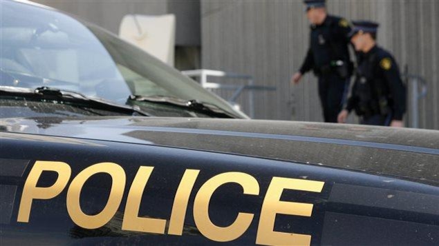 Deux agents de la police provinciale de l'Ontario derrière une autopatrouille. Deux agents de la police provinciale de l'Ontario derrière une autopatrouille.