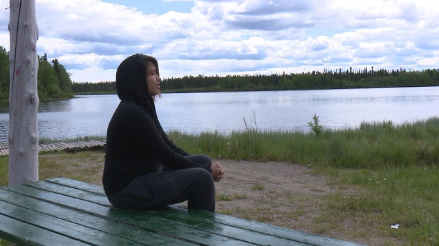 Une jeune femme au bord d'un lac