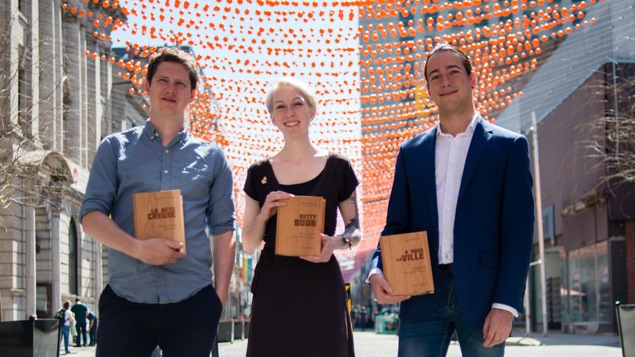 Le romancier Christophe Bernard, la bédéiste Véronique Cazot et et l'essayiste Jonathan Durand prennent la pose, avec leur prix entre les mains, sur la rue Sainte-Catherine, à Montréal, le 9 mai 2018.