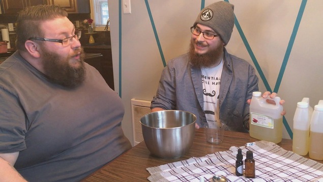 Deux hommes barbus assis à une table avec un bol et des ingrédients Deux hommes barbus assis à une table avec un bol et des ingrédients