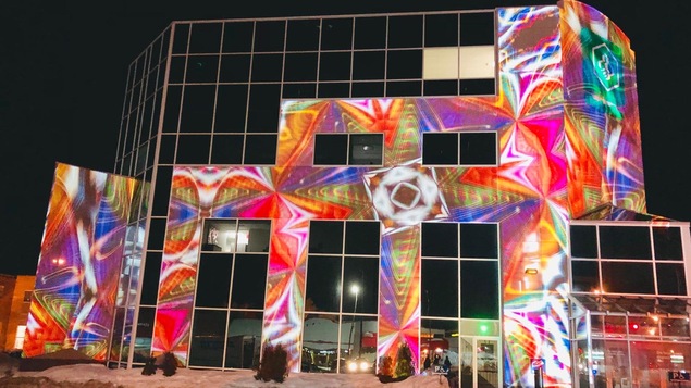 Une projection d'images sur un bâtiment vitré.