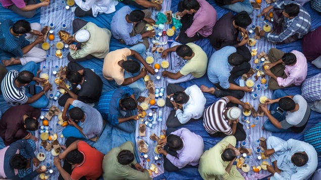 Des hommes mangent, assis sur des nappes déposées par terre, dans une mosquée lors du ramadan. Des hommes mangent, assis sur des nappes déposées par terre, dans une mosquée lors du ramadan.