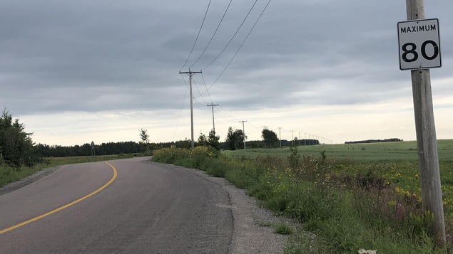 Une route rurale et une pancarte de limite de vitesse.