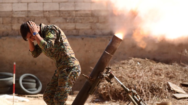 Un combattant kurde des Unités de protection du peuple kurde (YPG) lance une arête de mortier de 120 mm en se bouchant les oreilles à Raqqa, en Syrie. Un combattant kurde des Unités de protection du peuple kurde (YPG) lance une arête de mortier de 120 mm en se bouchant les oreilles à Raqqa, en Syrie.