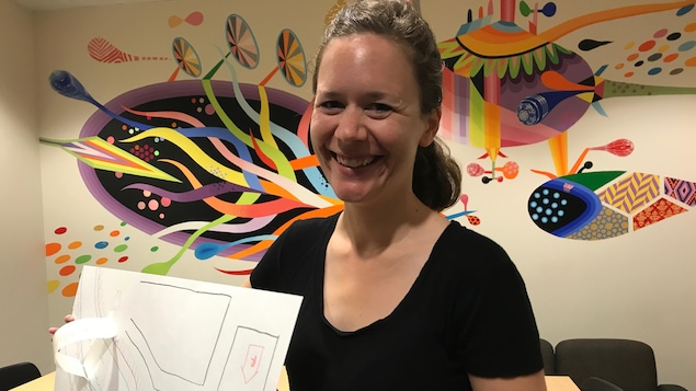 Renée Saurette tenant dans ses mains une cartes créée par les particpants de son atelier