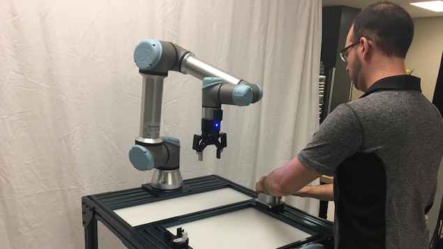 Un homme utilise un petit robot en forme de pince.