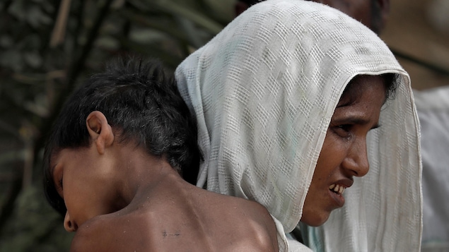 Une femme transporte un enfant malade dans un camp de réfugiés au Bangladesh.

