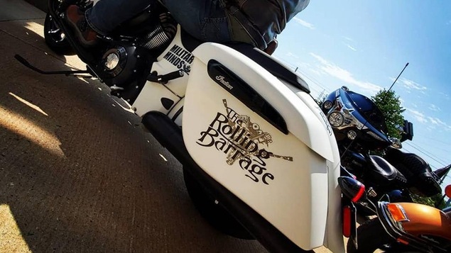 Un motocycliste qui participe au Rolling Barrage. Sa moto porte les couleurs de l'événement.